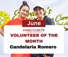 Photo of two women smiling. One wearing an orange shirt. The other is wearing a baseball hat.